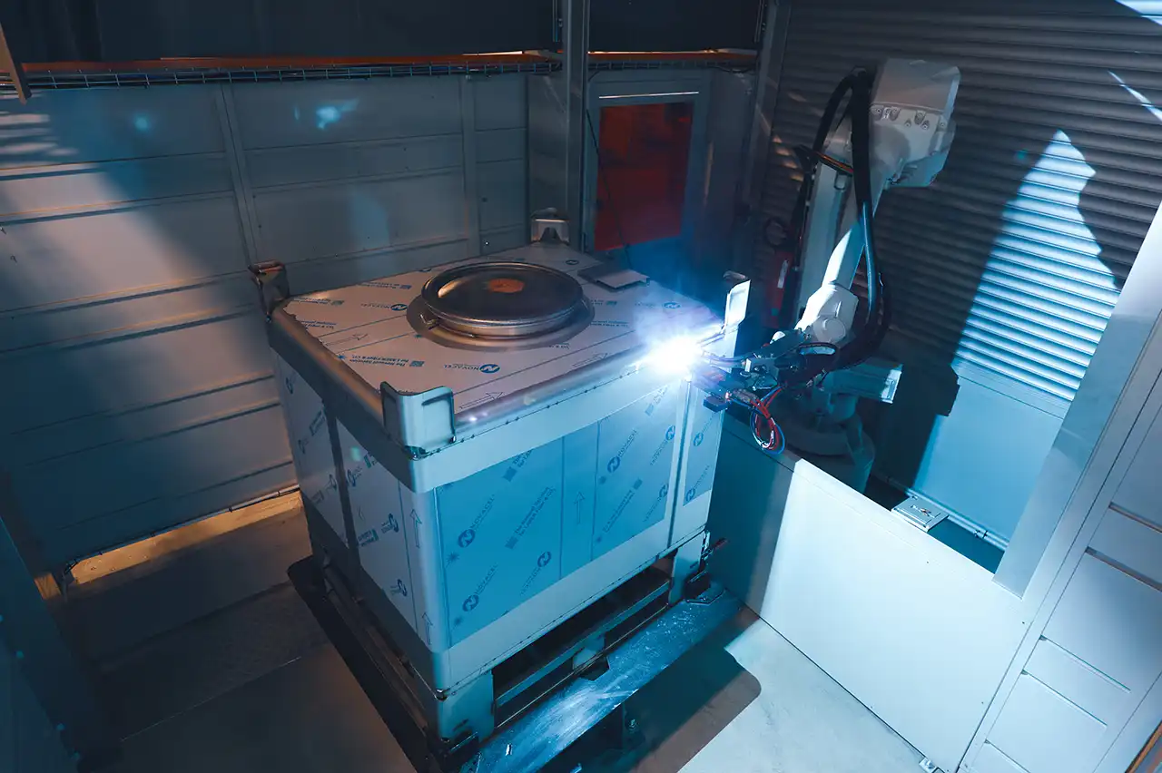 A robot welding an stainless steel IBC container at Finncont Image